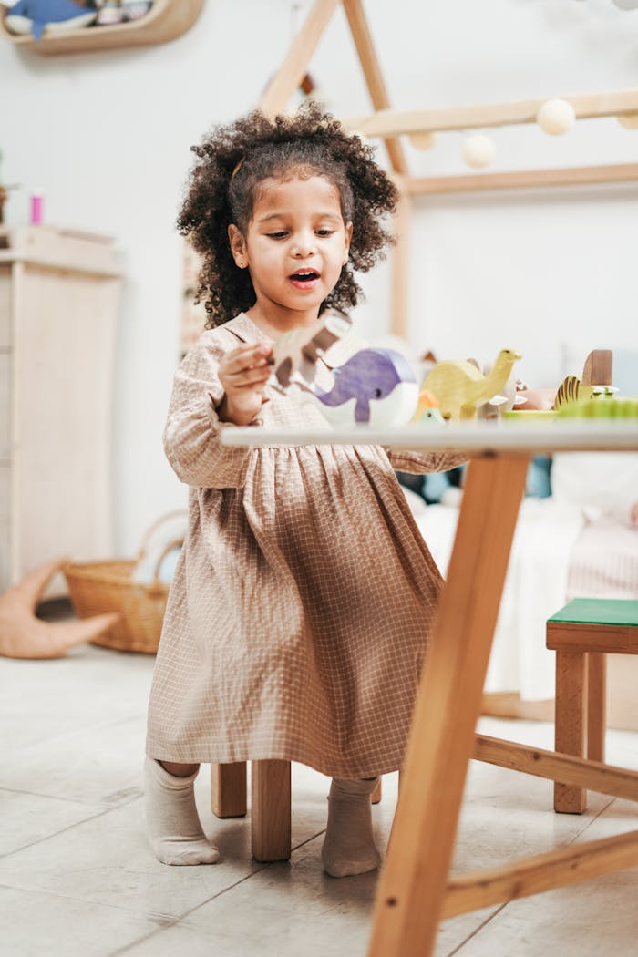 Adorable young girl enjoys playtime with wooden toys in a cozy playroom.